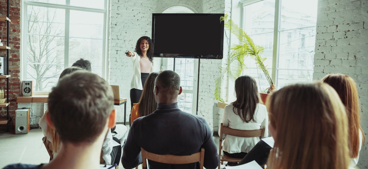 Female african-american speaker giving presentation in hall at university workshop